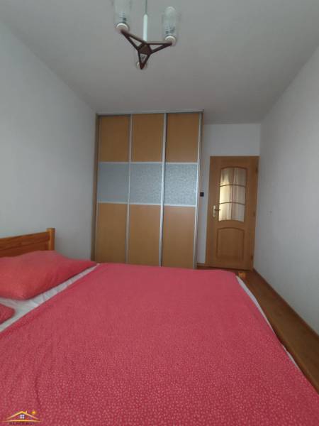 Schlafzimmer in einer 3-Zimmer-Wohnung mit Bett und Schrank mit Schiebetüren.