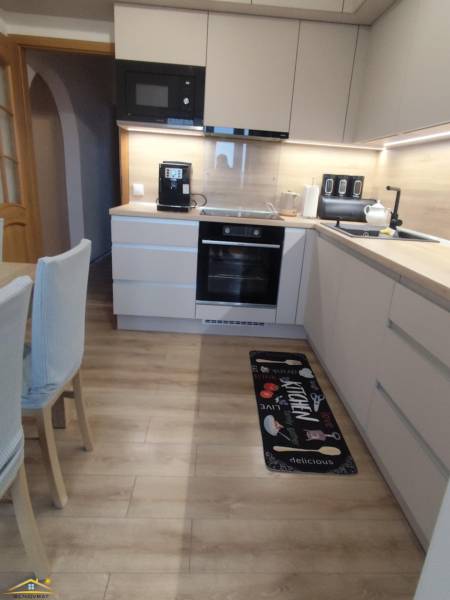 Küche mit Holzboden in einer 3-Zimmer-Wohnung, mit moderner Ausstattung und Dekor.