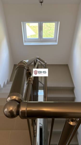 Eine Treppe mit einem Metallgeländer und einem Fenster in einer 3-Zimmer-Wohnung.