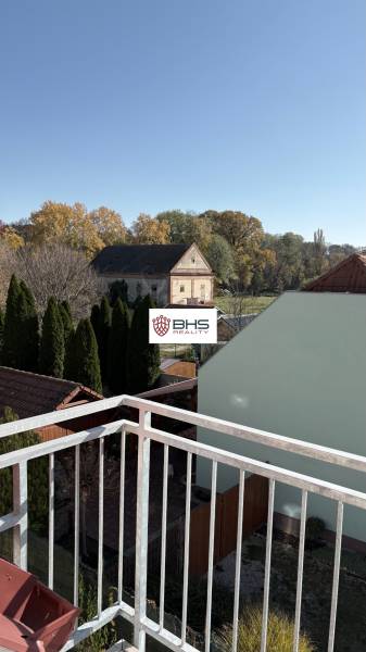 Der Ausblick aus der 3-Zimmer-Wohnung in Tomášikovo zeigt Gärten und ein altes Gebäude.