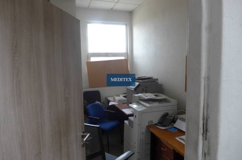 Kleines Büro mit Stühlen, Drucker und Fenster in Lagerhäusern und Hallen.