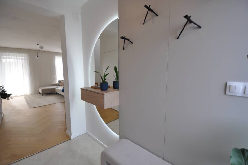 Innenraum eines Einfamilienhauses mit Holzboden, Spiegel und Zimmerpflanzen.