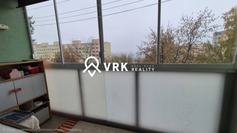 Ein verglaster Balkon in einer 3-Zimmer-Wohnung mit Blick auf Plattenbauten und Bäume.