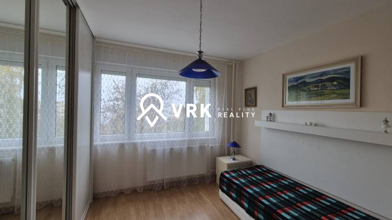 Ein Zimmer in einer 3-Zimmer-Wohnung mit einem Boden in Holzoptik und einer blauen Leuchte.