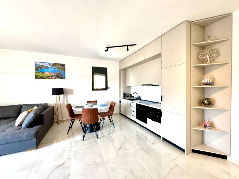 Helle Küche mit Esstisch und bequemer Couch in einer Einzimmerwohnung.