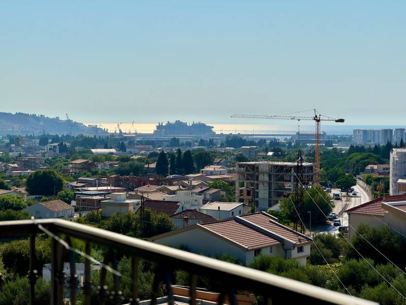 Blick auf die Stadt Bar mit Meerblick und Baukränen.