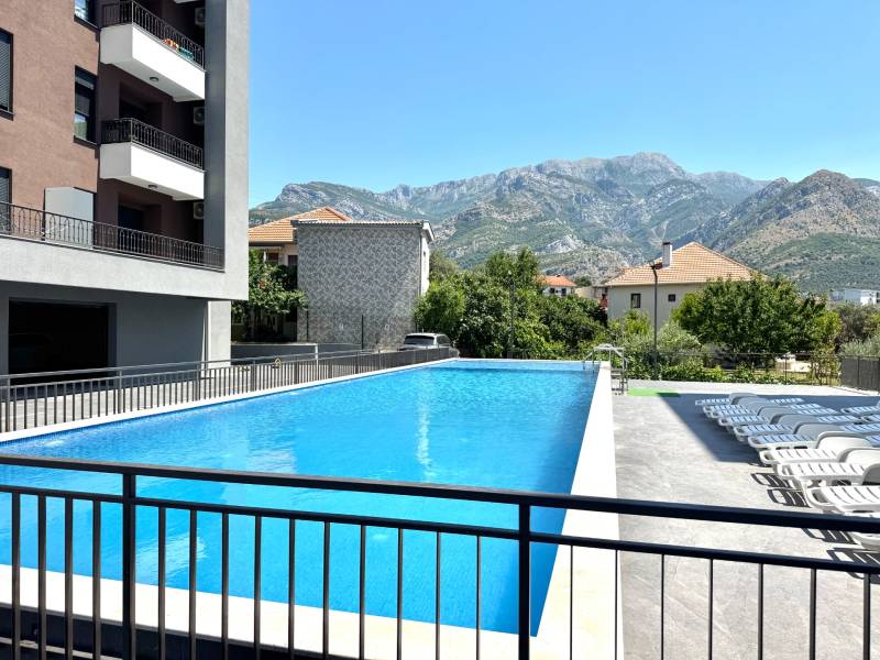 Ein Pool bei einer Einzimmerwohnung in der Stadt Bar mit Blick auf die Berge und Liegestühlen.