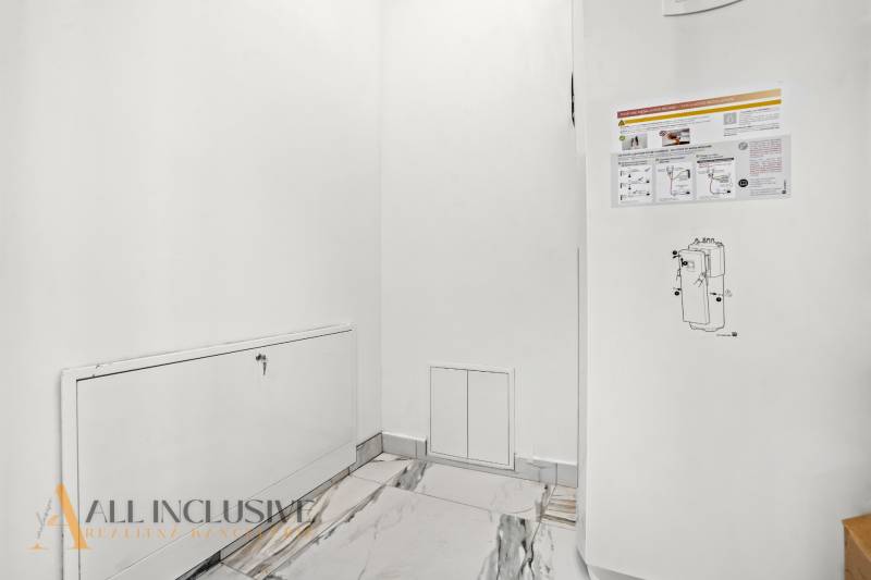 Weiße Wand mit Klappe und Informationsaufklebern in einem Einfamilienhaus.