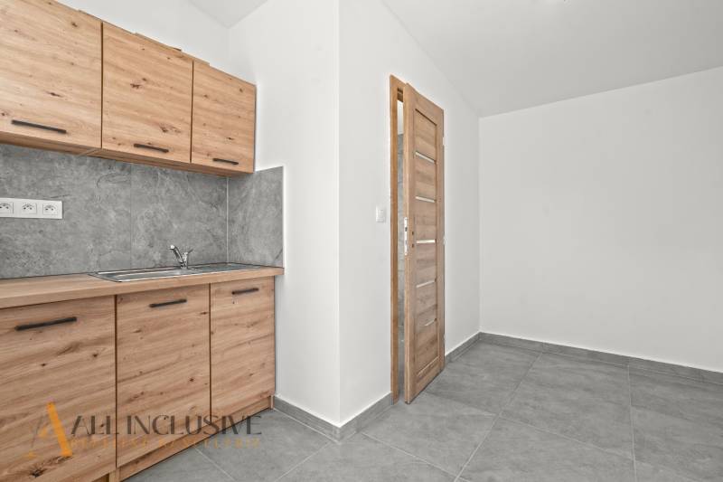 Küchenzeile mit Holzdekor und grauen Fliesen in einem Einfamilienhaus, Fliesenboden.