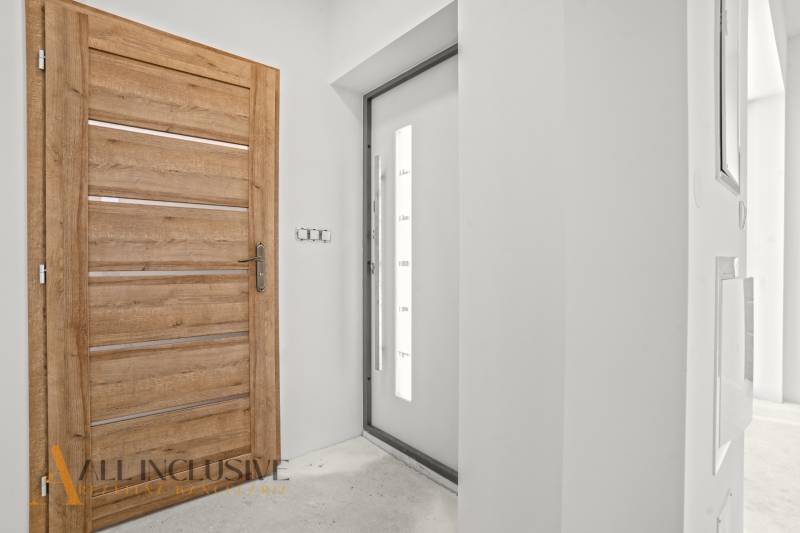 Innenraum eines Einfamilienhauses mit Holzelementen und einfachen weißen Wänden.