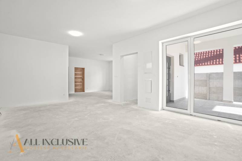 Geräumiges Interieur eines Einfamilienhauses mit weißen Wänden und großen Fenstern.