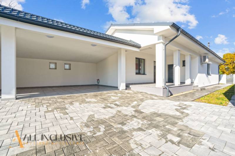Einfamilienhaus in Orechová Potôň mit Terrasse und Carport auf Pflastersteinen.