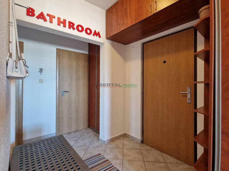 Eingangsflur mit Tür und Garderobe in einer 3-Zimmer-Wohnung, Fliesenboden.