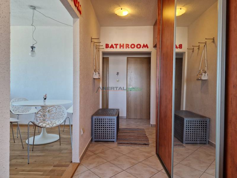 Flur einer 3-Zimmer-Wohnung mit Einbauschränken und Boden in Holzoptik.