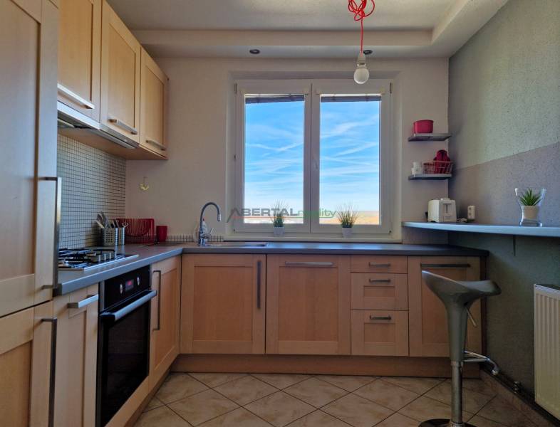 Küche mit Fenster, Boden mit Holzdekor, Fliesen, Einrichtung in einer 3-Zimmer-Wohnung.