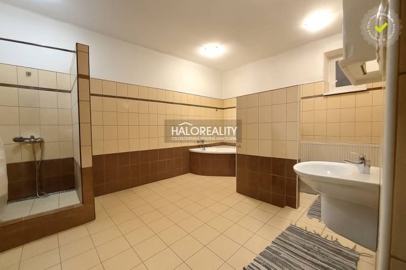 Schlafzimmer im Einfamilienhaus mit Bett, Schränken und Boden in Holzoptik.