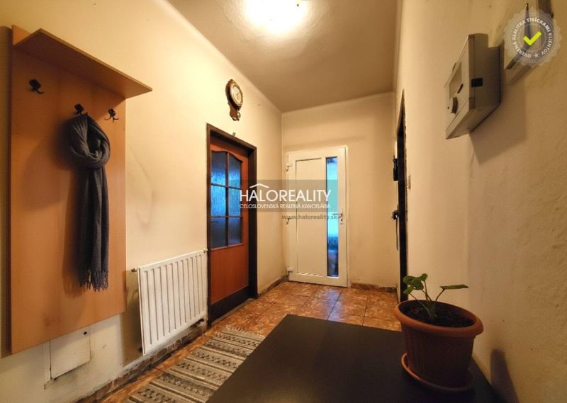 Schlafzimmer in einem Einfamilienhaus mit Bett, Fernseher auf einem Schrank und Boden mit Holzdekor.