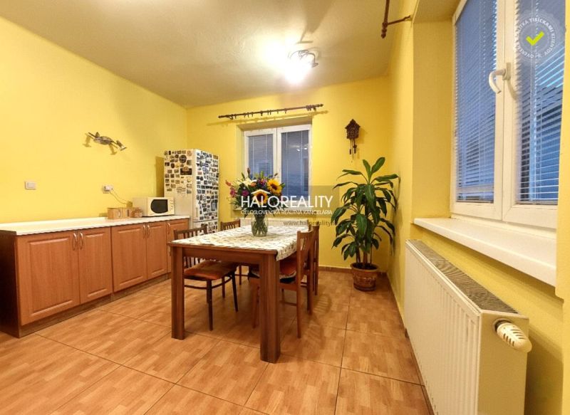 Wohnzimmer in einem Einfamilienhaus mit großer Eckcouch und Boden in Holzoptik.