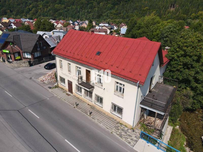 Das Gebäude in Belej mit dem roten Dach, die umliegenden Häuser und die Natur.