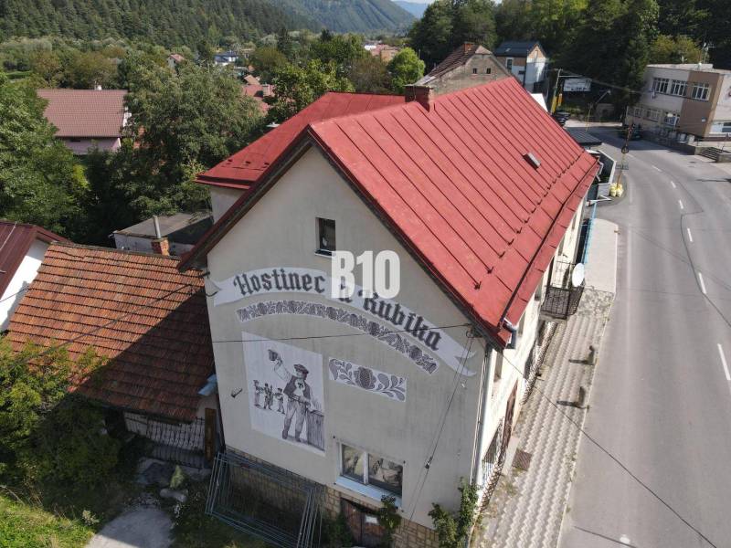 Das Gebäude des Gasthauses in Belá mit rotem Dach und einer Darstellung an der Wand.