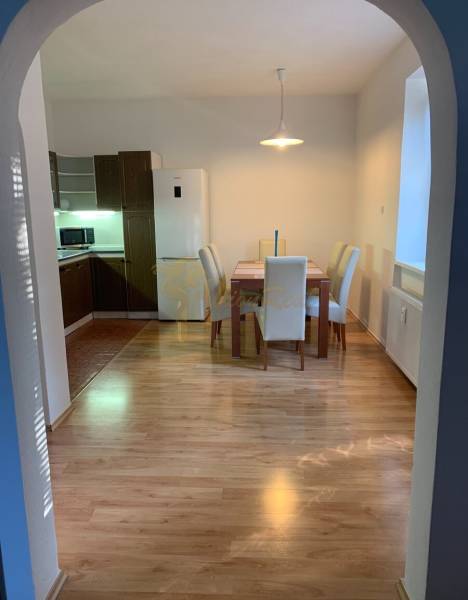 Essecke in einer 2-Zimmer-Wohnung mit Holzboden und vier Stühlen.