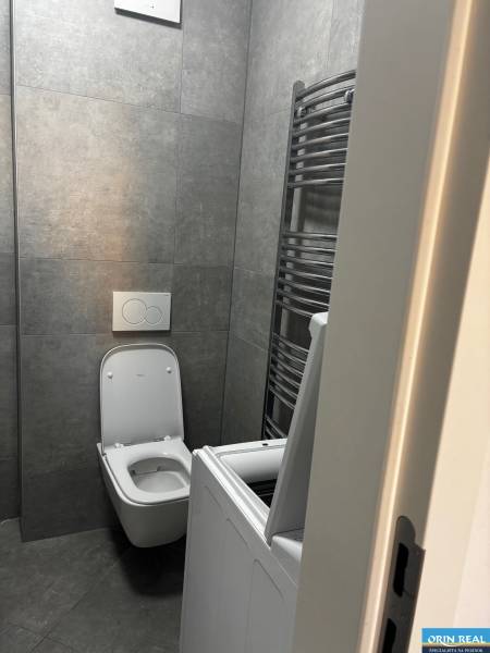 Badezimmer mit Fliesen, Waschmaschine und WC in einer 2-Zimmer-Wohnung.