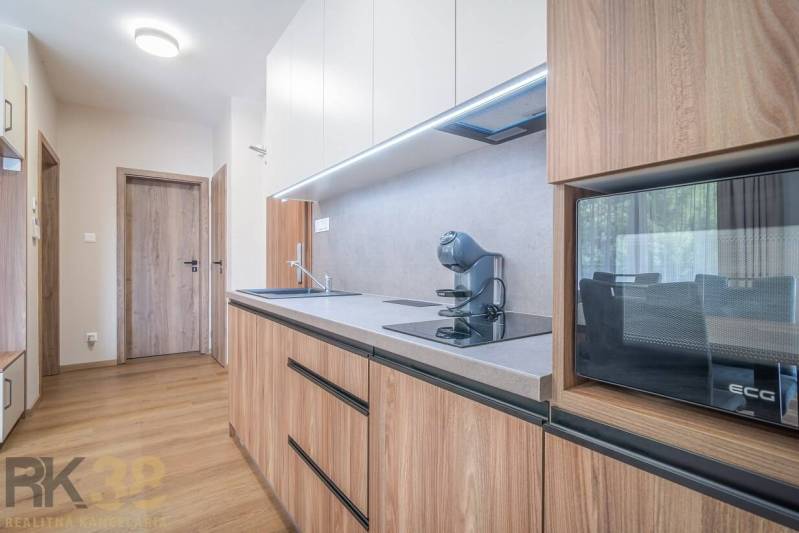 Küche in einer 2-Zimmer-Wohnung mit Holzboden und moderner Ausstattung.