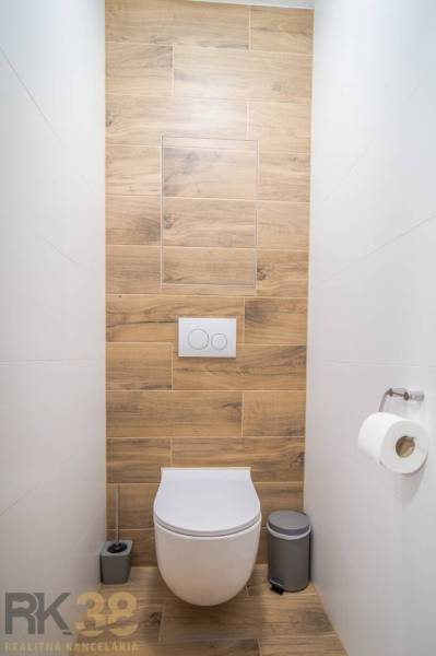Toilette mit hängendem WC und Boden in Holzoptik in einer 2-Zimmer-Wohnung.