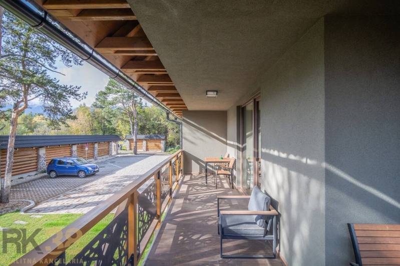 Balkon einer 2-Zimmer-Wohnung in Tatranská Lomnica mit Holzimitation und Außensitzbereich.