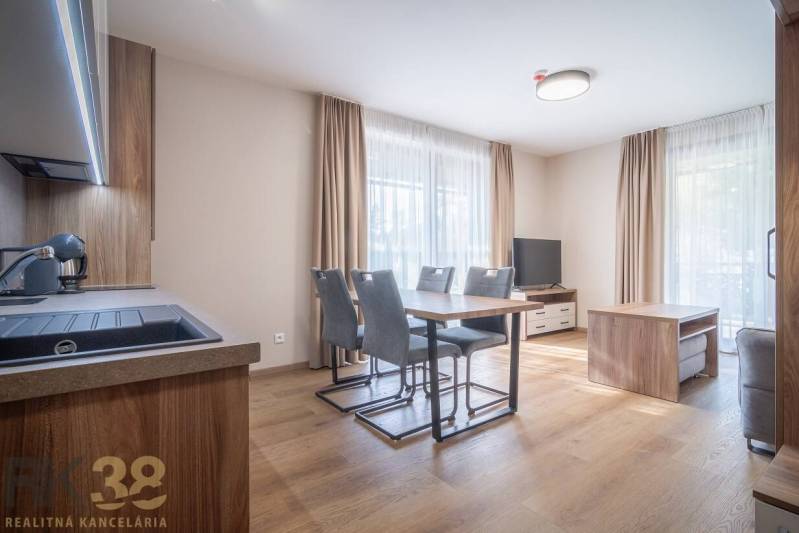 Geräumiges Interieur einer 2-Zimmer-Wohnung mit Holzboden und Esstisch.