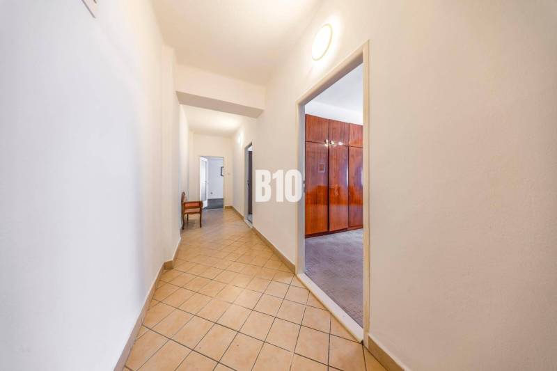 Flur mit Fliesen und Eingang zum Zimmer in einer 4-Zimmer-Wohnung.