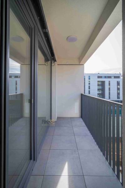 Balkon einer 2-Zimmer-Wohnung in Poprad mit Fliesen und Blick auf moderne Gebäude.