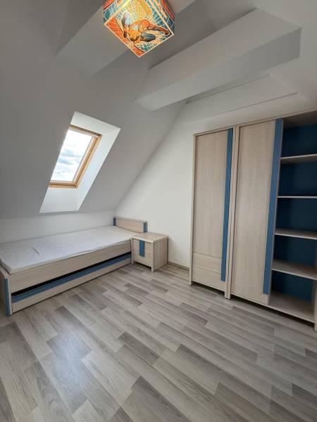 Kinderzimmer mit Dachfenster, Bett und Schrank in einer 4-Zimmer-Wohnung.