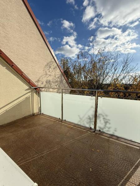 Balkon einer 4-Zimmer-Wohnung in der Pekníkova-Straße in Pezinok mit Blick auf die Baumwipfel.