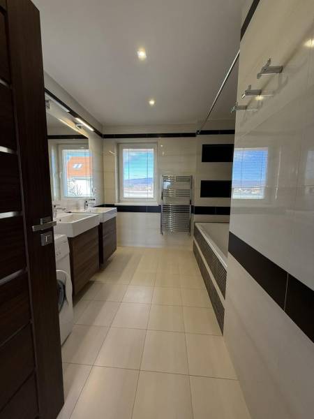 Badezimmer in einer 4-Zimmer-Wohnung mit Badewanne, Waschbecken und Waschmaschine.