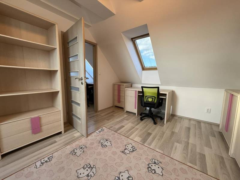 Ein Zimmer in einer 4-Zimmer-Wohnung mit einem Holzboden und einer Arbeitsecke.
