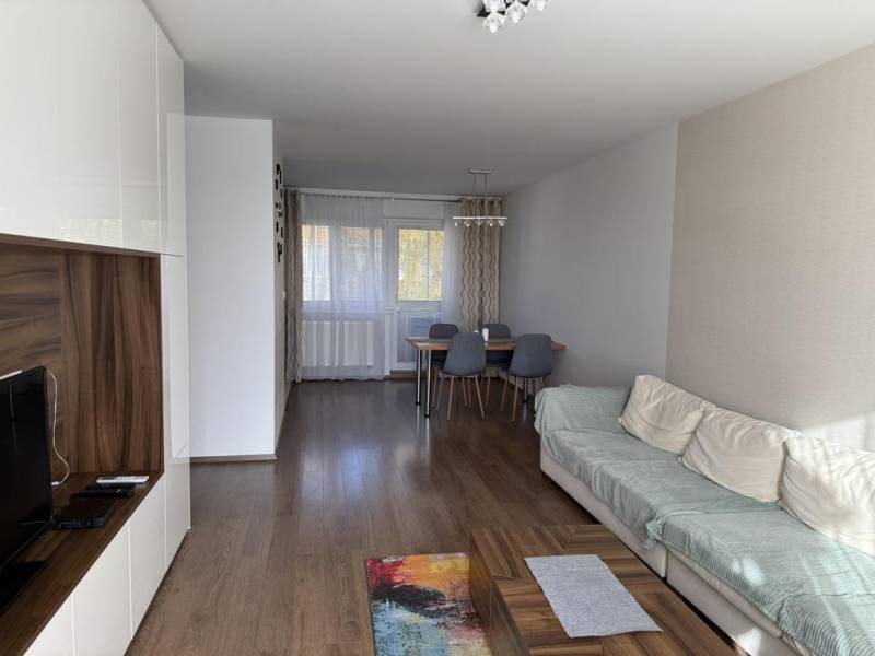 Wohnzimmer in einer 4-Zimmer-Wohnung mit Holzboden und Esstisch.