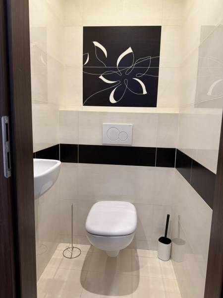 Badezimmer mit hängendem WC und Waschbecken in einer 4-Zimmer-Wohnung, verziert mit Blumenmotiven.