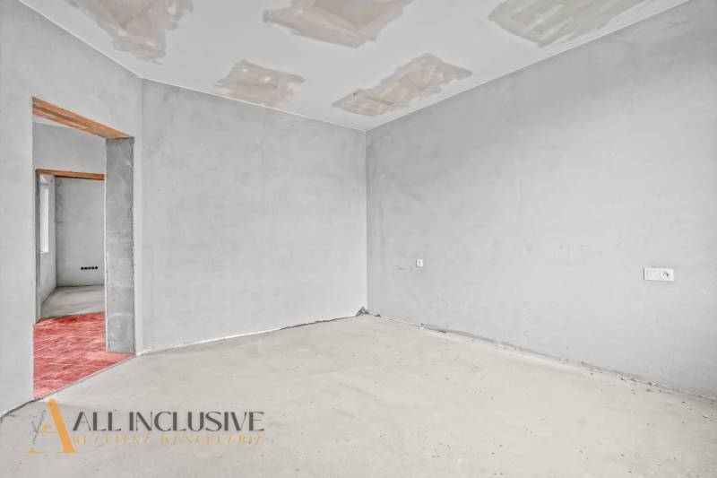 Ein Zimmer in einem Einfamilienhaus mit unfertigem Boden und Decke.