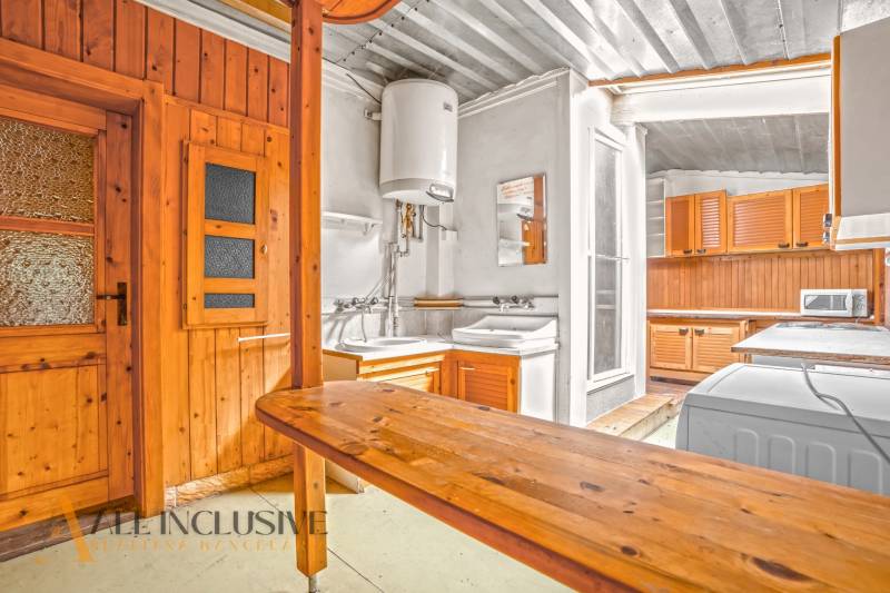 Küche in einem Einfamilienhaus mit Holzverkleidung und praktischer Ausstattung.