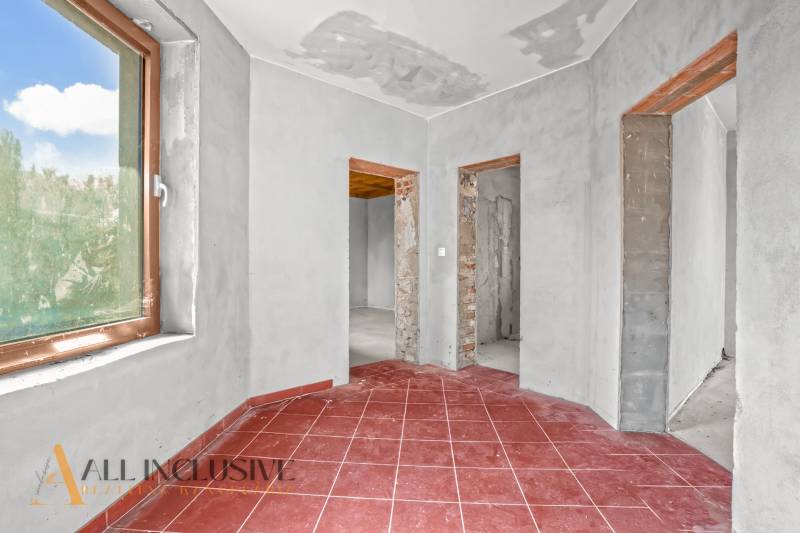 Ein Einfamilienhaus mit roten Fliesen, verputzten Wänden und drei offenen Durchgängen.