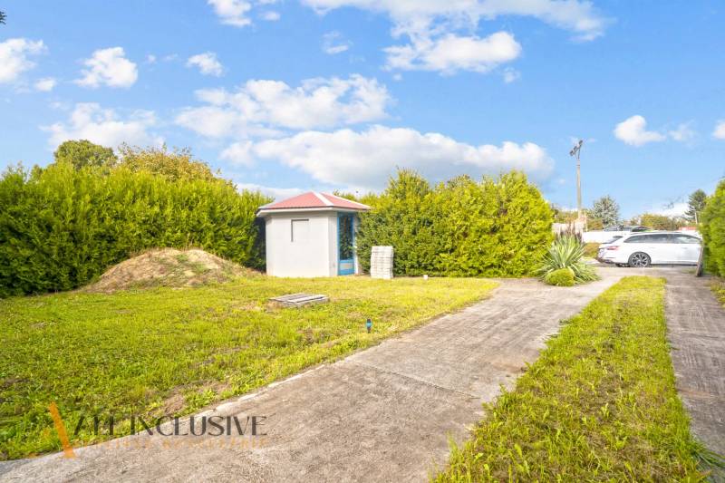 Der Hof beim Einfamilienhaus in Bátorove Kosihy mit Rasen und Gartenhäuschen.