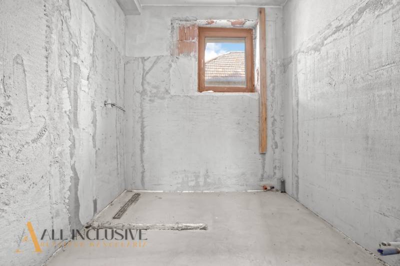 Badsanierung in einem Einfamilienhaus, Wände aus unbehandeltem Beton, nur ein kleines Fenster.