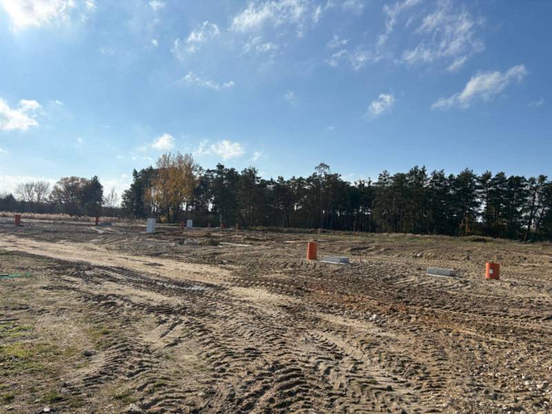 Grundstücke zum Wohnen in der Straße Pod Borovicou in Studienka, umgeben von Bäumen und blauem Himmel.