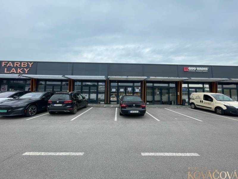 Geschäftsräume in der Brnianska-Straße in Trenčín mit einem Parkplatz vor den Geschäften.