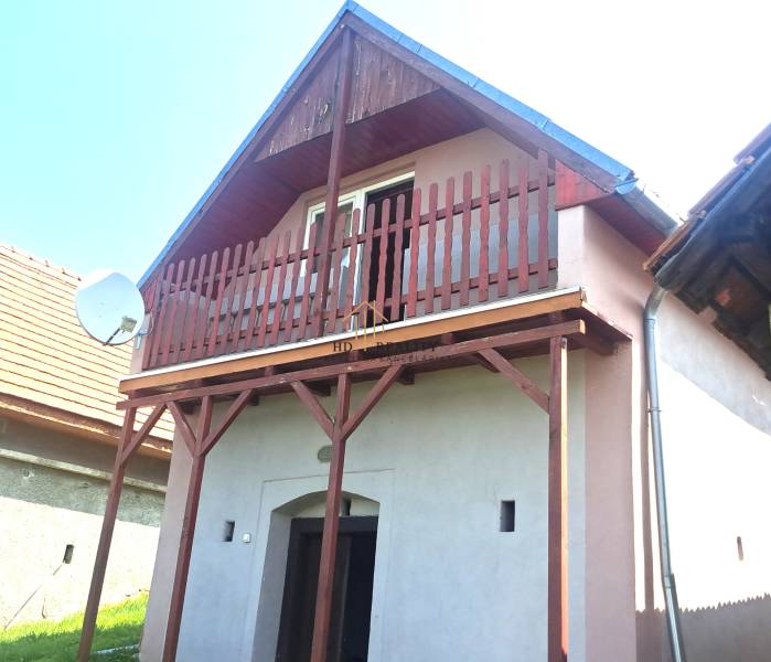 Ein Ferienhaus in Hontianske Trsťany mit einem Holzbalkon und einer Satellitenschüssel.