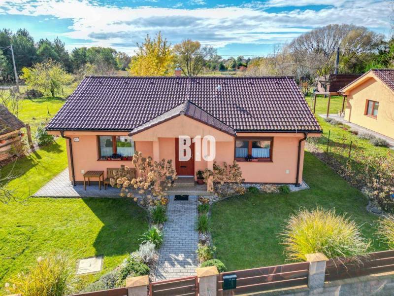 Ein Einfamilienhaus in Bílkove Humence mit gepflegtem Garten und terrakottafarbener Fassade.