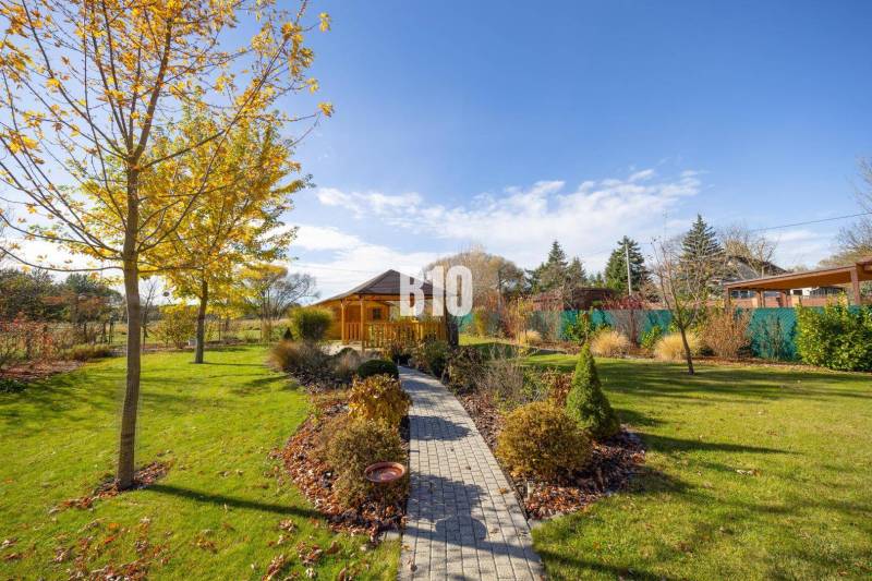 Der Garten in Bílkova Humence mit einem Pavillon und Bäumen, die mit bunten Blättern geschmückt sind, in einem Einfamilienhaus.
