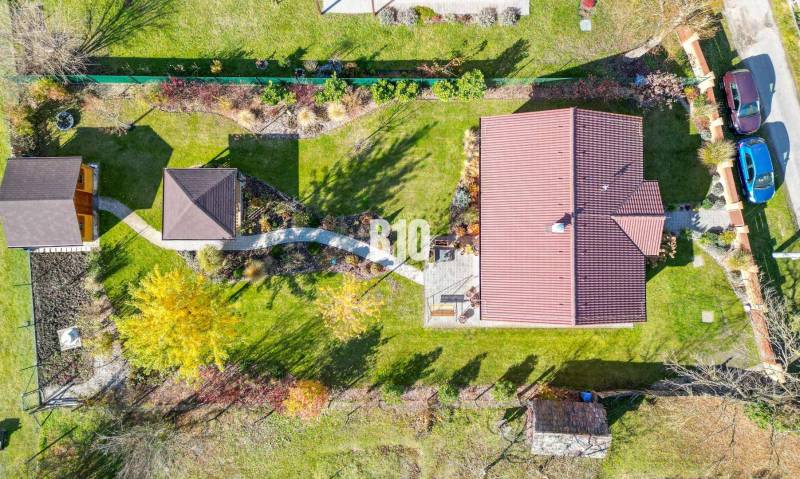 Ein Einfamilienhaus in Bílikové Humence mit einem großen Garten und zwei Autos im Hof.