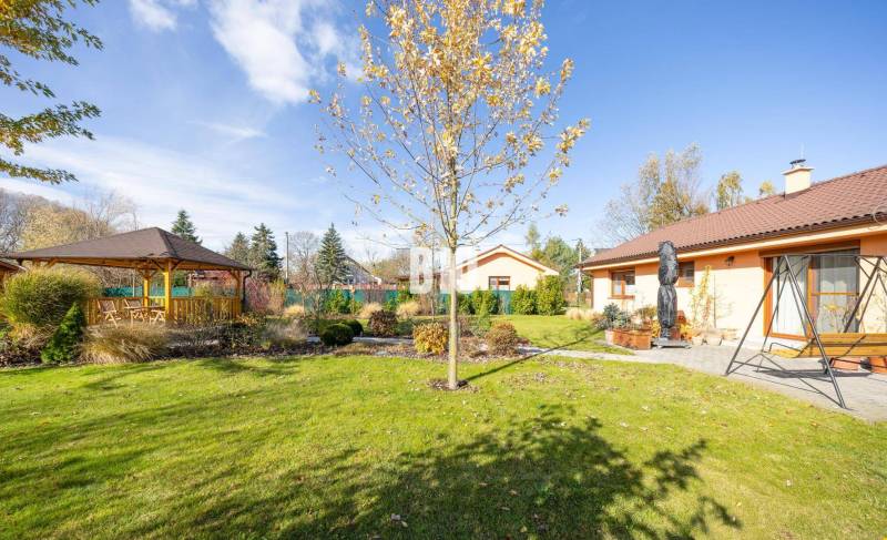 Ein Garten mit Pavillon bei einem Einfamilienhaus in Bílkova Humence, umgeben von Grün.